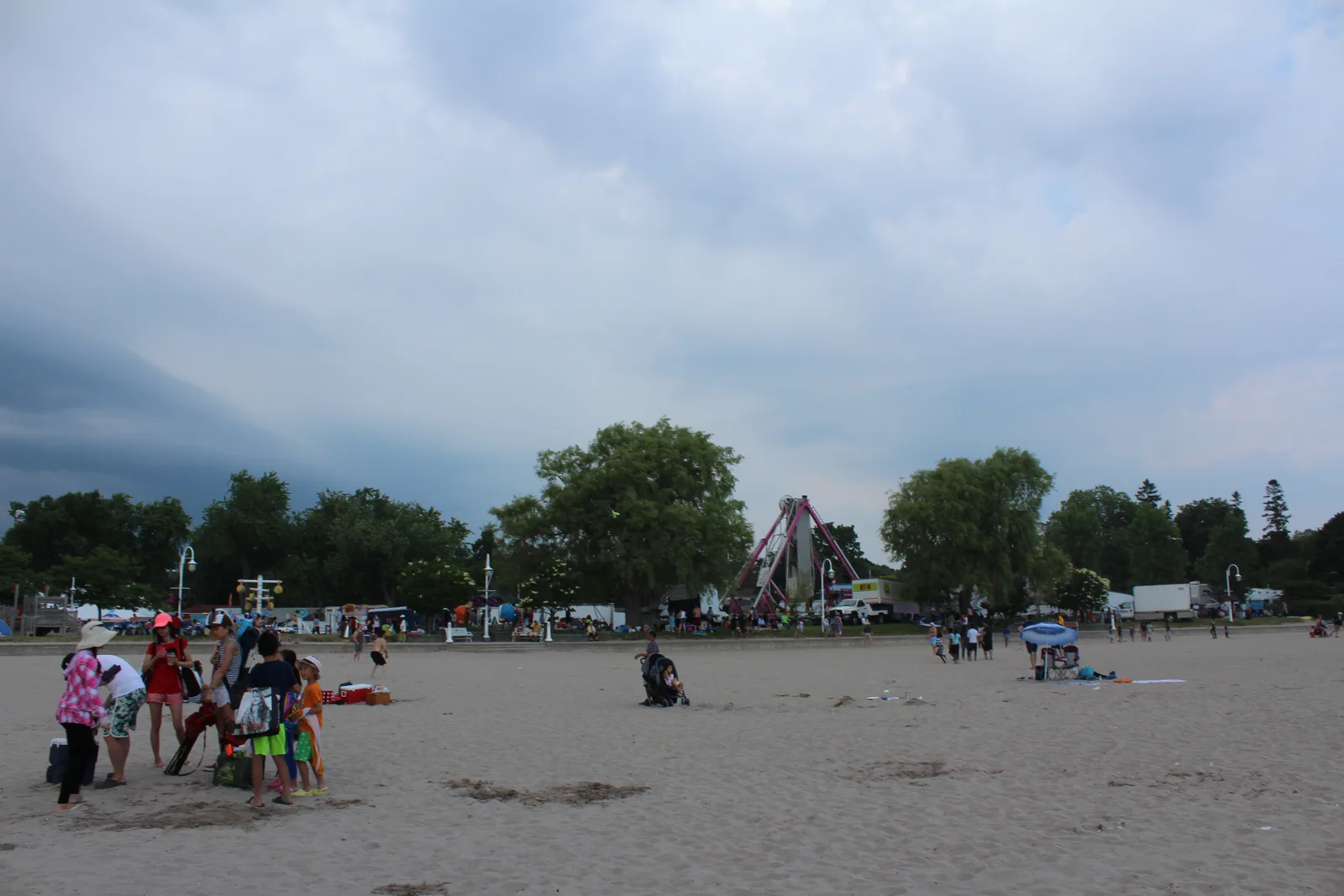 People enjoying the sandy waterfront beside Victoria Park in Cobourg